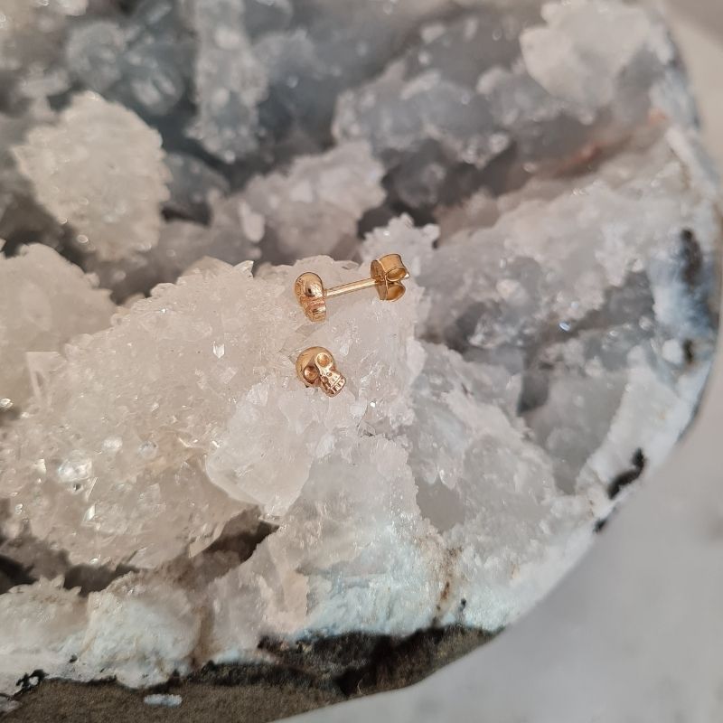 tiny skull stud earrings in yellow gold