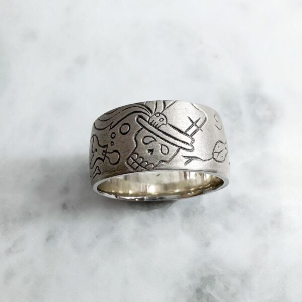 Wide silver ring featuring a satin finish and voodoo symbols and markings.