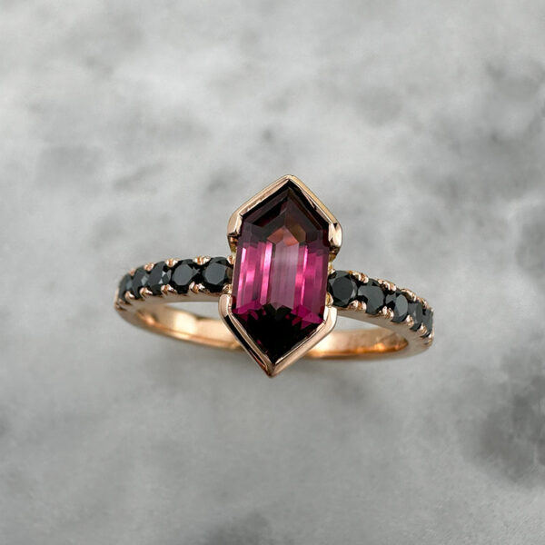 Rose gold ring set with hexagonal cut rhodolite garnet and black diamonds