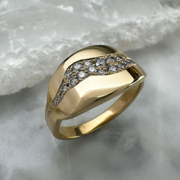 gold ring with wide and flat profile set with a cluster of diamonds